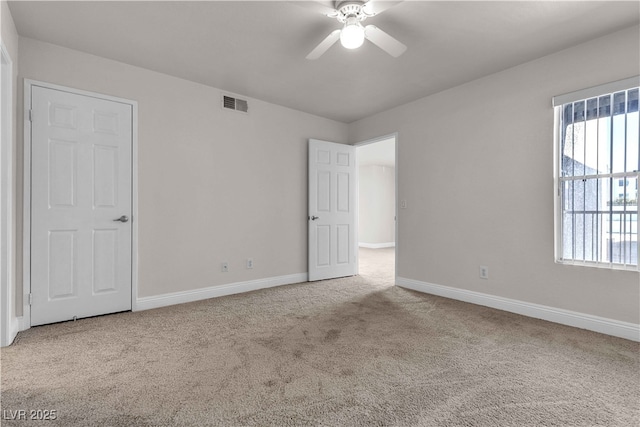 carpeted spare room featuring ceiling fan and a healthy amount of sunlight