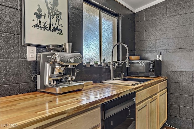 kitchen featuring butcher block countertops, sink, hardwood / wood-style floors, and vaulted ceiling