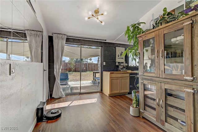 doorway to outside with a notable chandelier and dark wood-type flooring