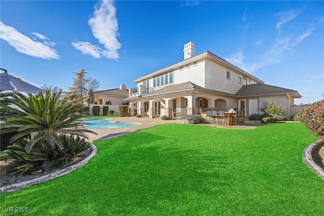 rear view of house with a lawn, a patio area, a balcony, and a bar