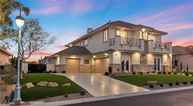 view of front of property with a lawn, a balcony, and a garage