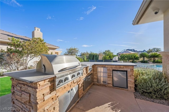 view of patio featuring an outdoor kitchen and a grill