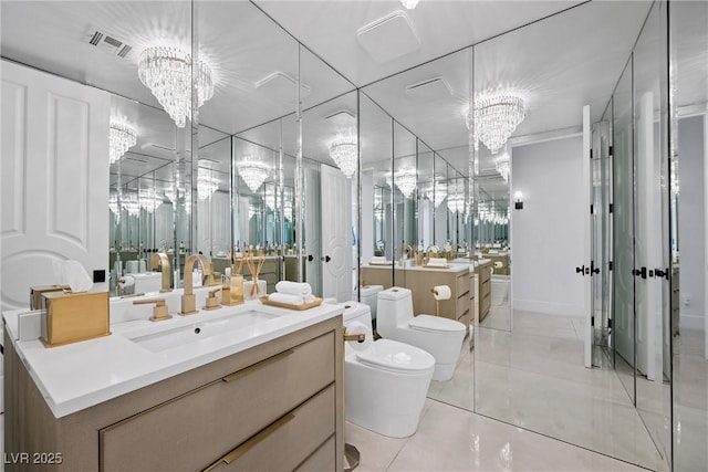 bathroom featuring tile patterned flooring, vanity, a chandelier, and toilet