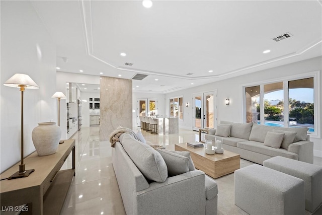 living room featuring a raised ceiling, plenty of natural light, light tile patterned floors, and french doors