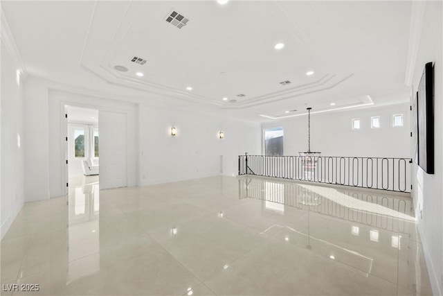 unfurnished room with light tile patterned floors, crown molding, and a tray ceiling