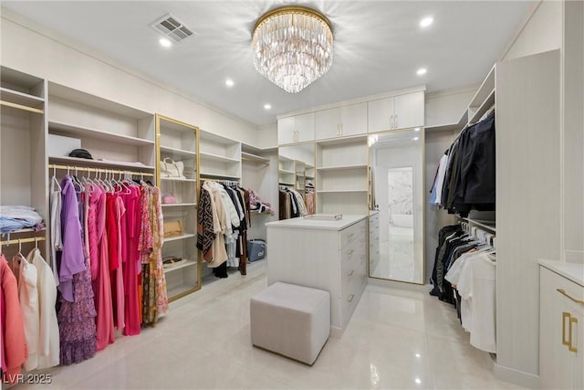 spacious closet featuring light tile patterned floors and a notable chandelier