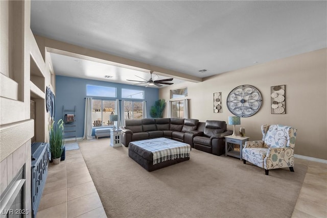 living room with ceiling fan, light tile patterned flooring, and beamed ceiling