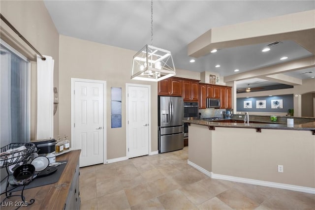 kitchen featuring ceiling fan, pendant lighting, a kitchen bar, kitchen peninsula, and stainless steel appliances