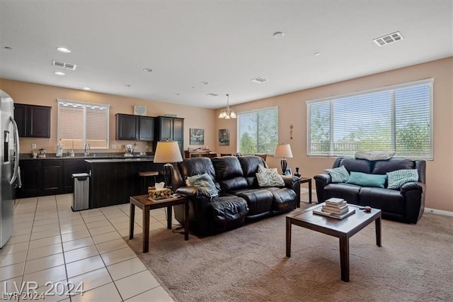 living room featuring light tile patterned floors, a notable chandelier, and sink