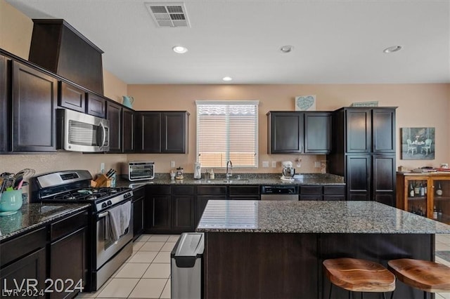 kitchen with a center island, sink, stainless steel appliances, and light tile patterned flooring