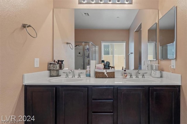 bathroom with vanity and a shower with door