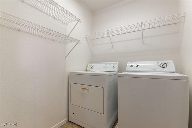 laundry area featuring washing machine and clothes dryer and light tile patterned floors