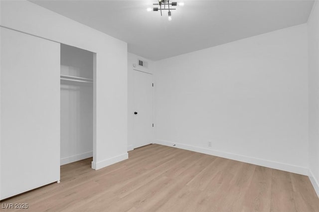 unfurnished bedroom with a closet and light hardwood / wood-style flooring