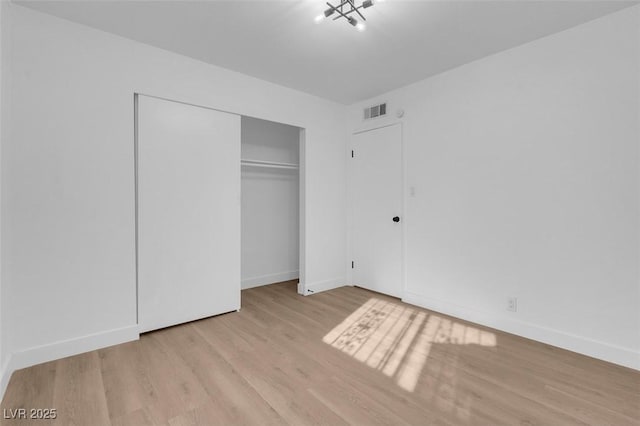 unfurnished bedroom with a closet and light hardwood / wood-style flooring