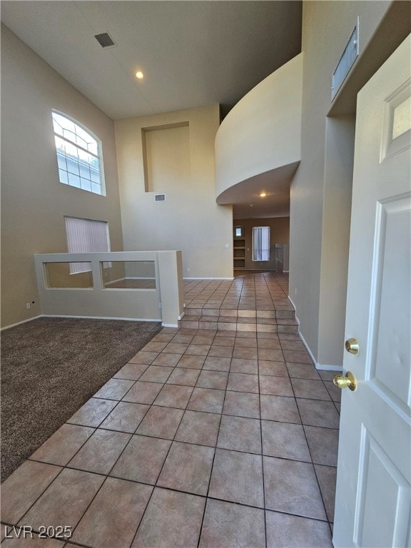 entrance foyer featuring light tile patterned floors and a high ceiling