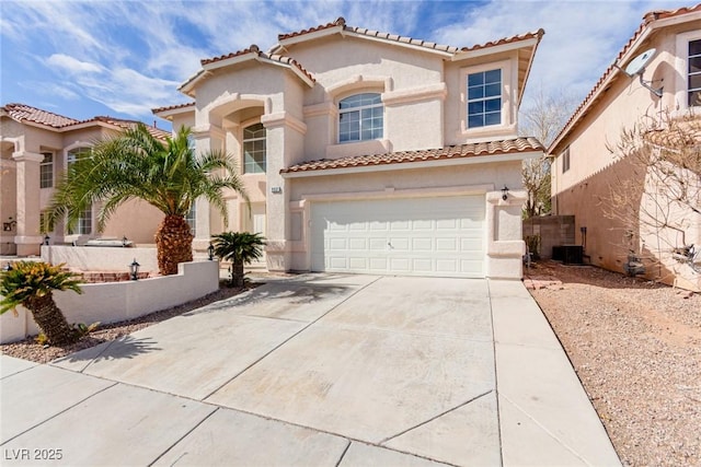 mediterranean / spanish house featuring a garage, driveway, a tiled roof, and stucco siding