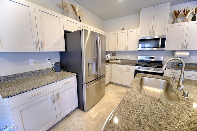 kitchen featuring white cabinetry, sink, stainless steel appliances, and light stone counters