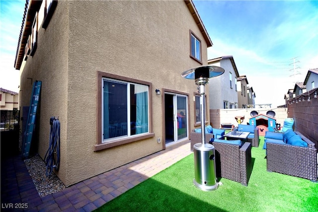 rear view of property with outdoor lounge area, a patio, and a lawn