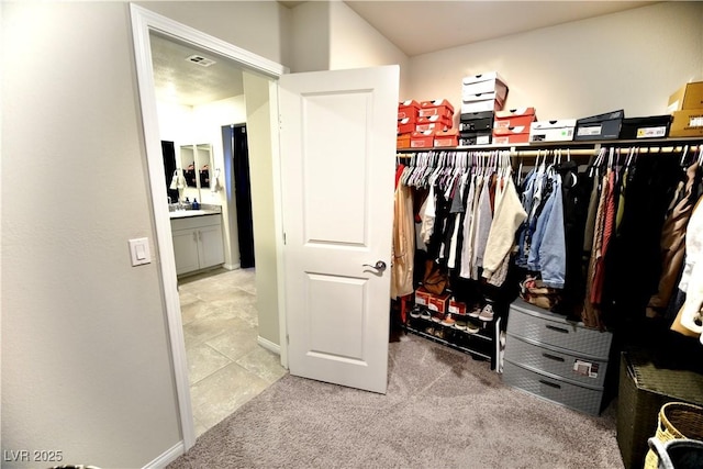 walk in closet featuring light colored carpet