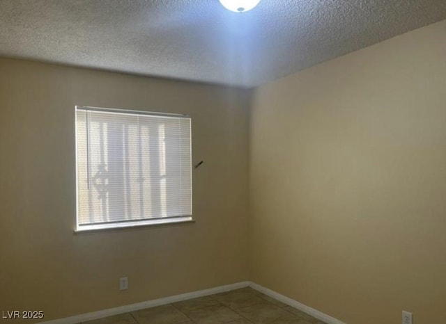 tiled spare room featuring a textured ceiling