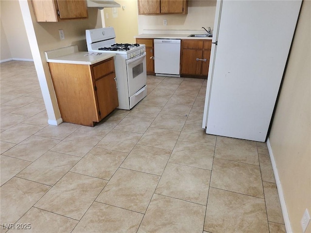 kitchen with sink, light tile patterned floors, exhaust hood, and white appliances