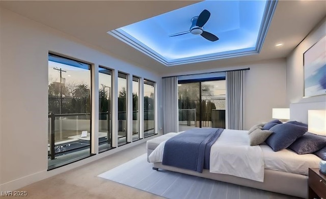 carpeted bedroom featuring ceiling fan and a raised ceiling