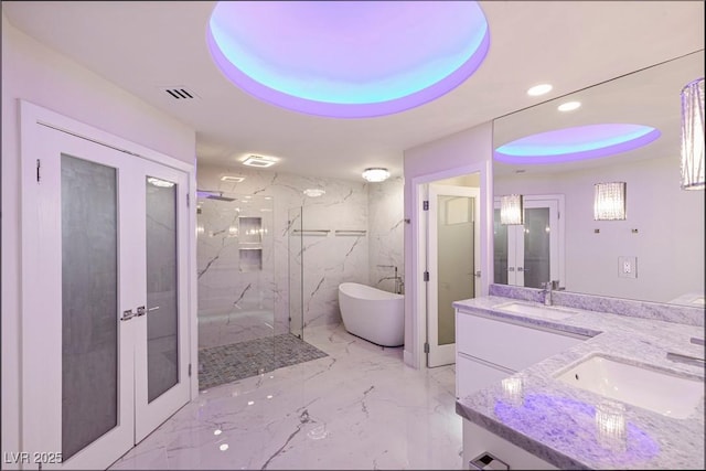 bathroom featuring vanity, plus walk in shower, and french doors