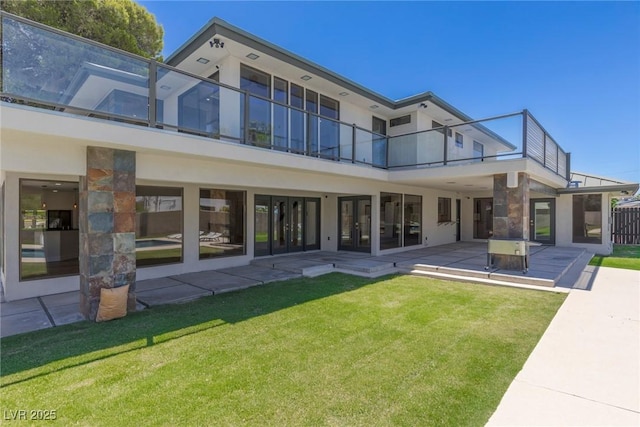 back of property with a yard and a patio area