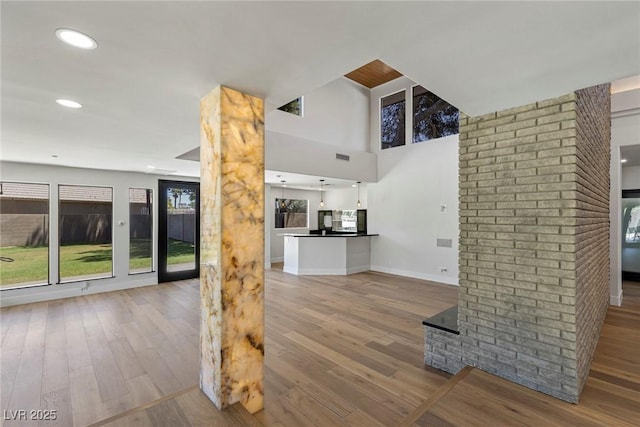 unfurnished living room featuring light hardwood / wood-style flooring and ornate columns