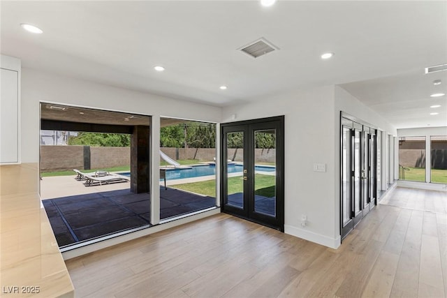 doorway to outside with french doors and light hardwood / wood-style floors