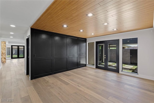 empty room featuring wooden ceiling, french doors, and light wood-type flooring