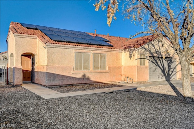 view of side of property with a garage and solar panels