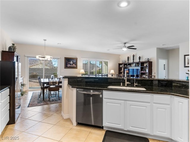 kitchen featuring black refrigerator, stainless steel dishwasher, dark stone counters, sink, and pendant lighting