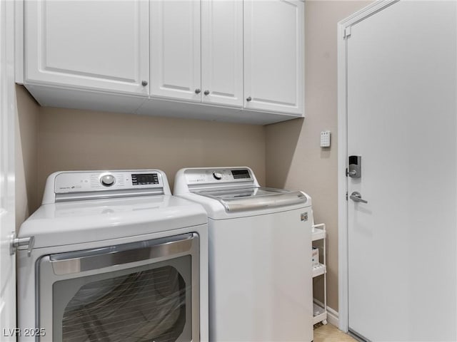 clothes washing area featuring separate washer and dryer and cabinets