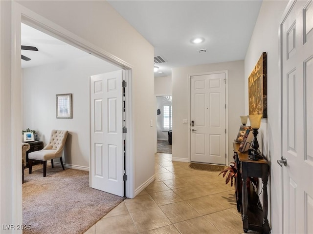 foyer featuring light carpet and ceiling fan