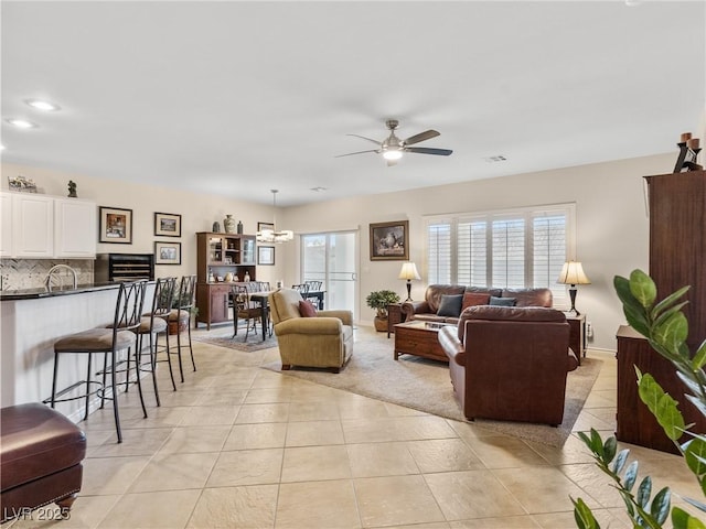 living room with ceiling fan with notable chandelier and light tile patterned flooring