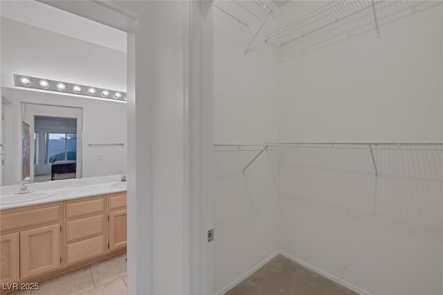 spacious closet featuring light tile patterned flooring and sink