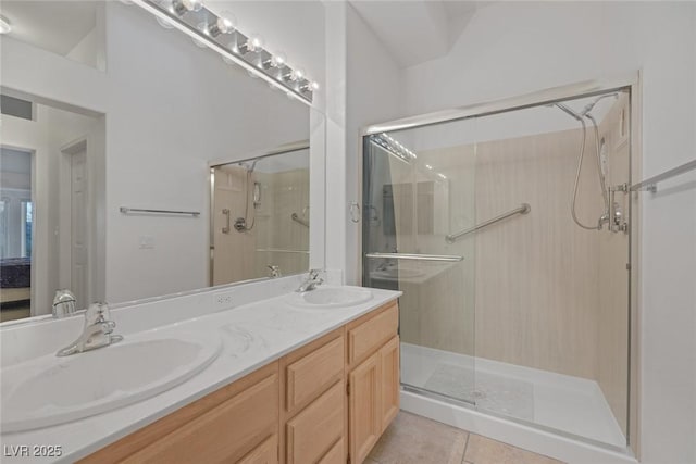 bathroom with tile patterned floors, a shower with door, and vanity