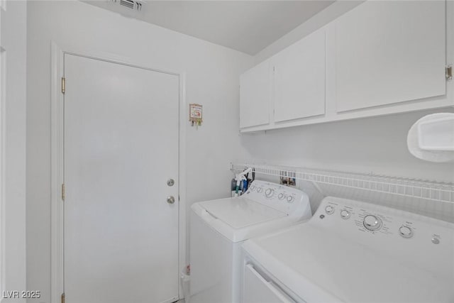 laundry room featuring washing machine and dryer and cabinets