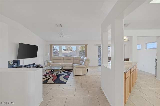 living room featuring ceiling fan, light tile patterned floors, and vaulted ceiling