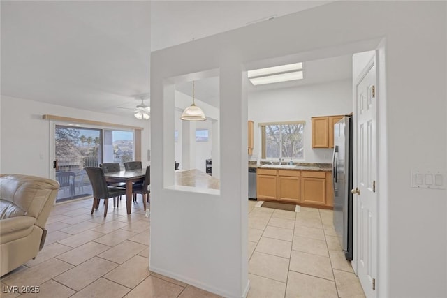 kitchen featuring stainless steel appliances, ceiling fan, sink, decorative light fixtures, and light tile patterned flooring