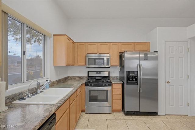 kitchen with sink, light tile patterned floors, light brown cabinets, and appliances with stainless steel finishes