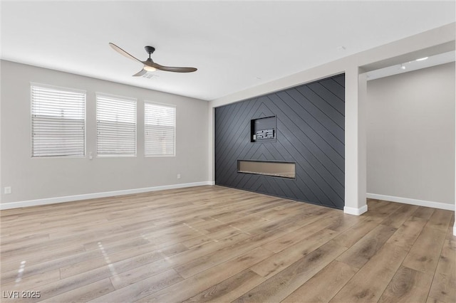 spare room with ceiling fan and light wood-type flooring