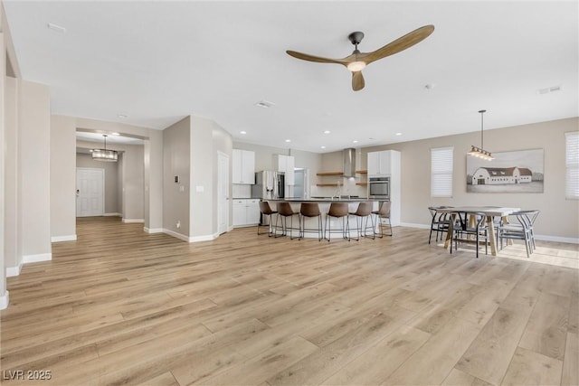 living room featuring light hardwood / wood-style flooring and ceiling fan