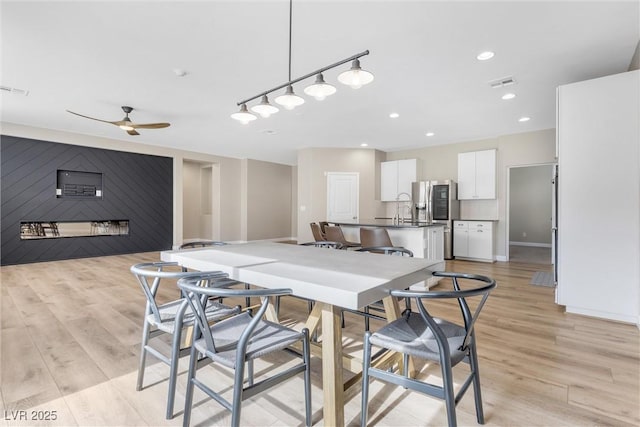 kitchen with hanging light fixtures, light hardwood / wood-style flooring, white cabinetry, and ceiling fan