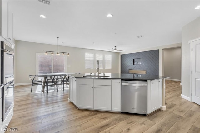 kitchen with white cabinetry, dishwasher, ceiling fan, hanging light fixtures, and sink