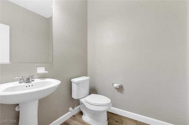 bathroom with toilet and wood-type flooring