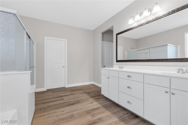 bathroom with vanity, an enclosed shower, and hardwood / wood-style flooring