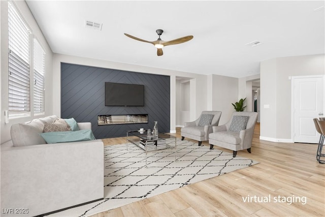 living room with light hardwood / wood-style floors and ceiling fan