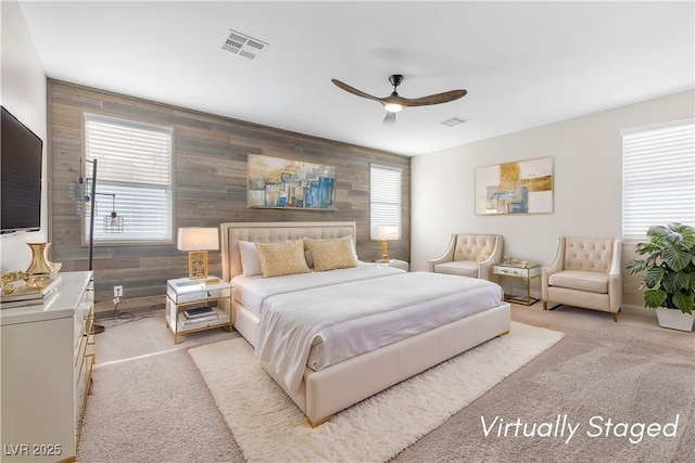 carpeted bedroom featuring wooden walls and ceiling fan